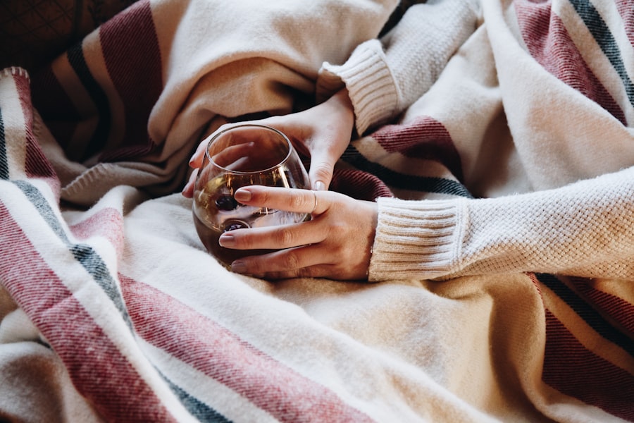 Hands holding a warm drink wrapped in a cozy blanket