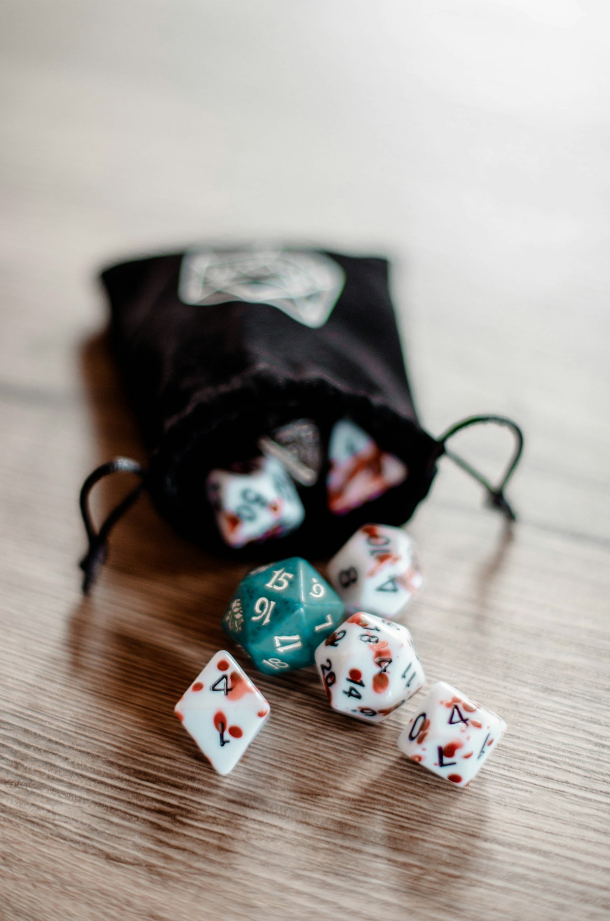 A cloth bag of polyhedral dice resting on a wooden table