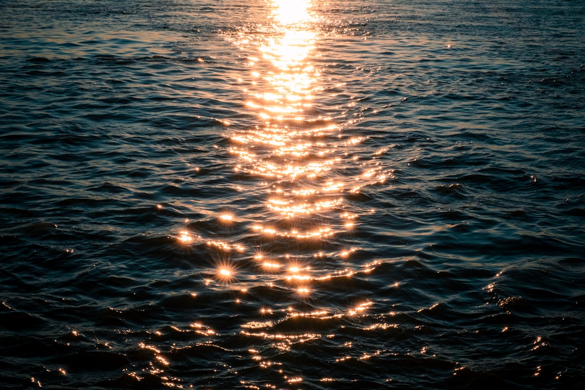 Sunlight path rippling across ocean water at golden hour